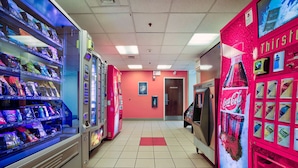 Un espace dédié à la vente automatique, avec différents distributeurs de collations et de boissons, dont un distributeur de Coca-Cola et un distributeur de la marque Thirsty.