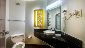 Un baño moderno con inodoro, lavamanos y espejo.