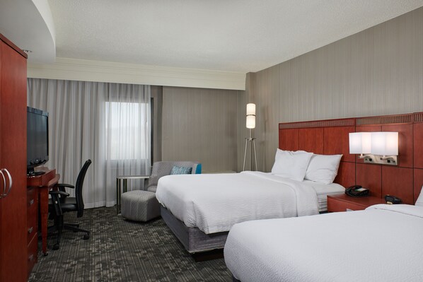 A hotel room with two beds, a desk with a chair, a television, and a lamp. - Courtyard by Marriott Bristol (Bristol)