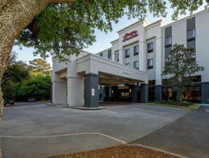 A hotel entrance with a sign reading "Hampton Inn & Suites."