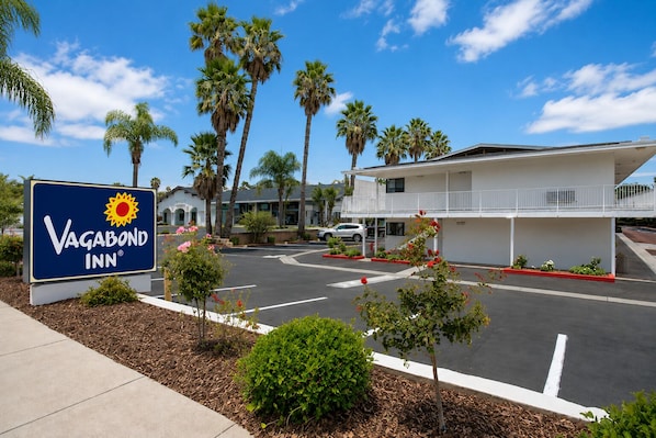 A VAGABOND INN sign, a building with a balcony, and palm trees.