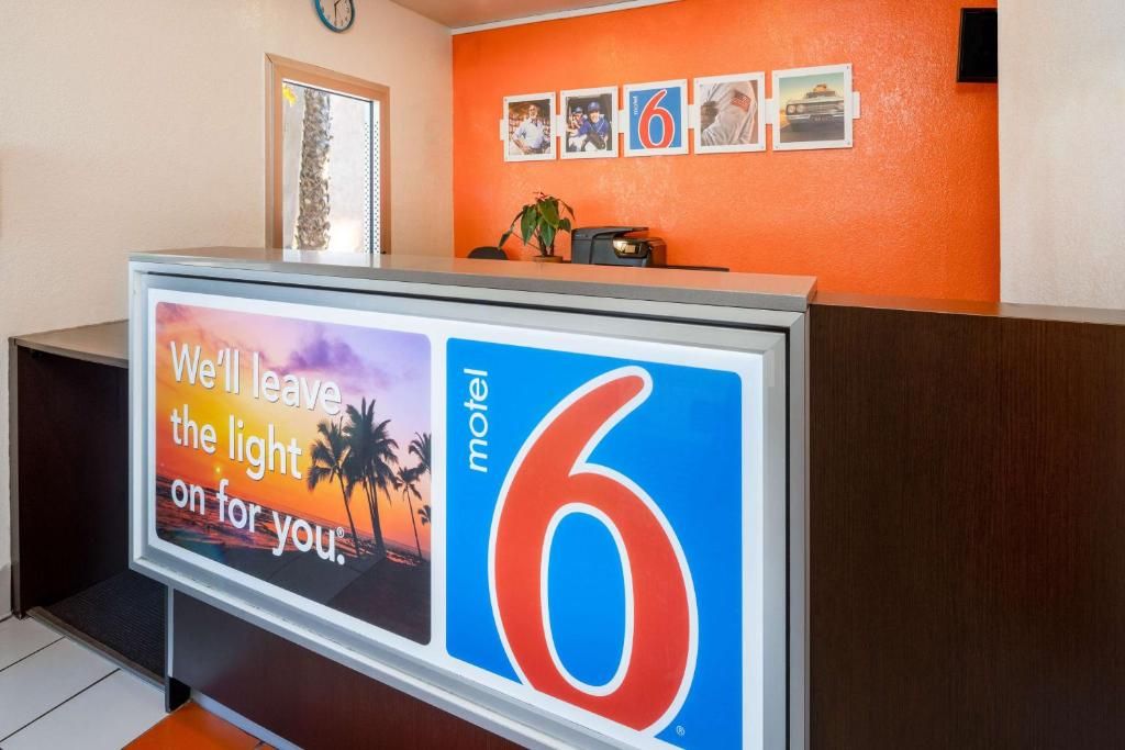 A reception desk with a sign indicating it's room number 6 at a motel.
