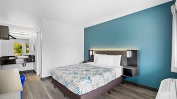 A modern hotel room with a large bed, a desk, and a chair.