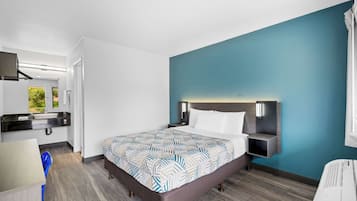 Ett modernt hotellrum med en stor säng, ett skrivbord och ett badrum.