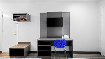 Une chambre moderne équipée d’un bureau, d’une chaise, d’une télévision et d’une armoire.