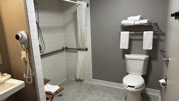 A bathroom with a shower, toilet, and sink.