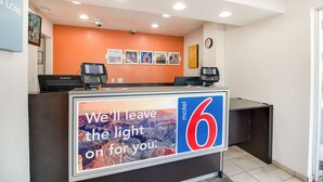 A hotel reception desk with a large sign reading "We'll leave the light on for you." - Motel 6-Phoenix, AZ - East (Phoenix)