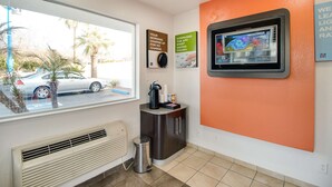 A room with a window, a wall-mounted TV, a trash bin, and a cabinet. - Motel 6-Phoenix, AZ - East (Phoenix)