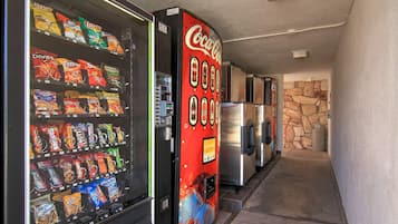 Máquina expendedora de snacks y Coca-Cola en un pasillo.