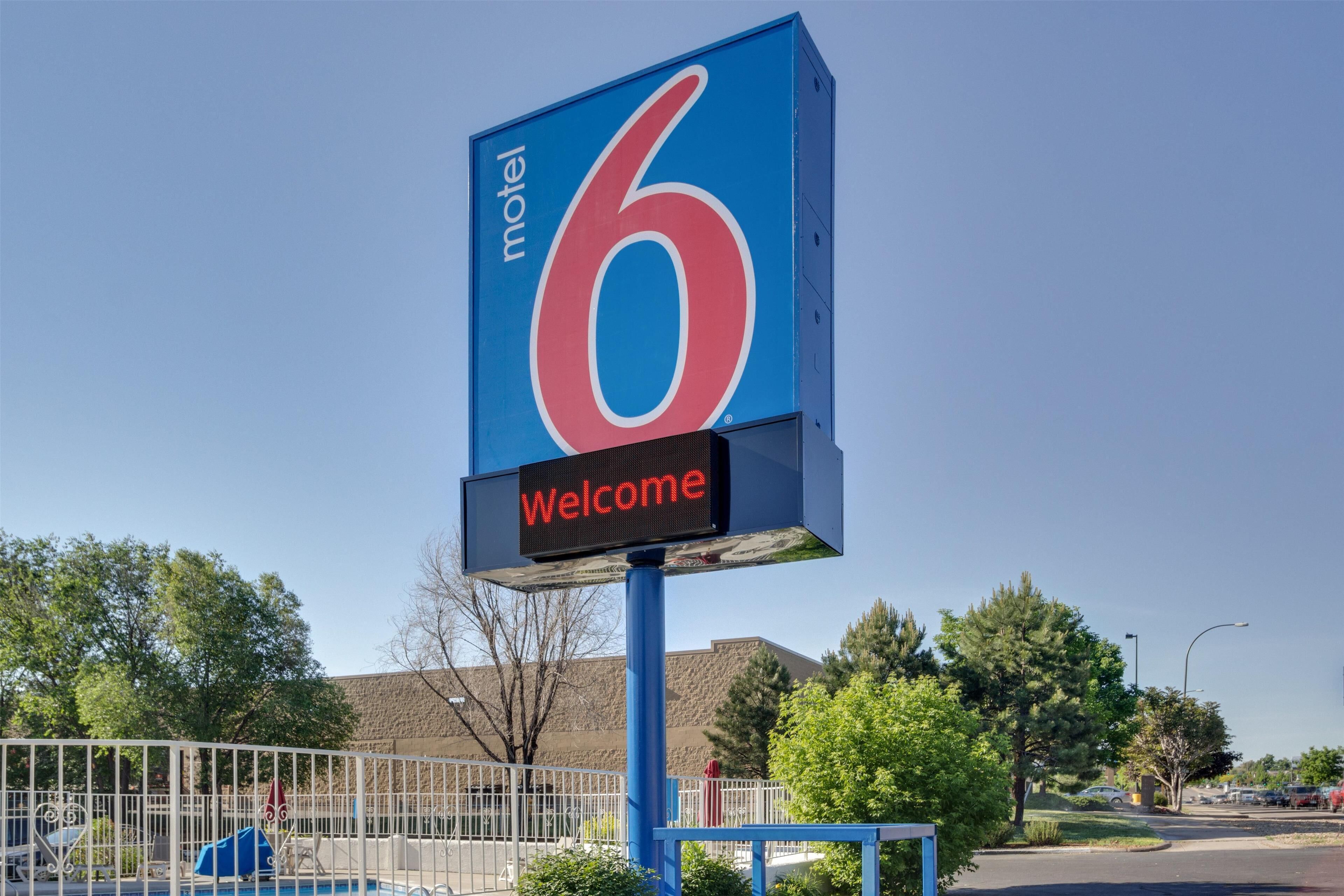Letrero de motel con el número 6 y un mensaje de bienvenida.