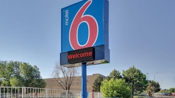 Letrero de motel con el número 6 y un mensaje de bienvenida.