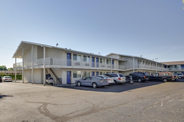 A motel with multiple floors, a parking lot, and several cars parked in front. - Motel 6 – Lakewood, CO (Lakewood)
