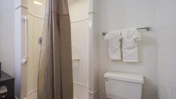 A bathroom with a shower, toilet, and towel rack.
