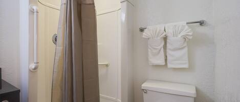 A bathroom with a shower, toilet, and towel rack.