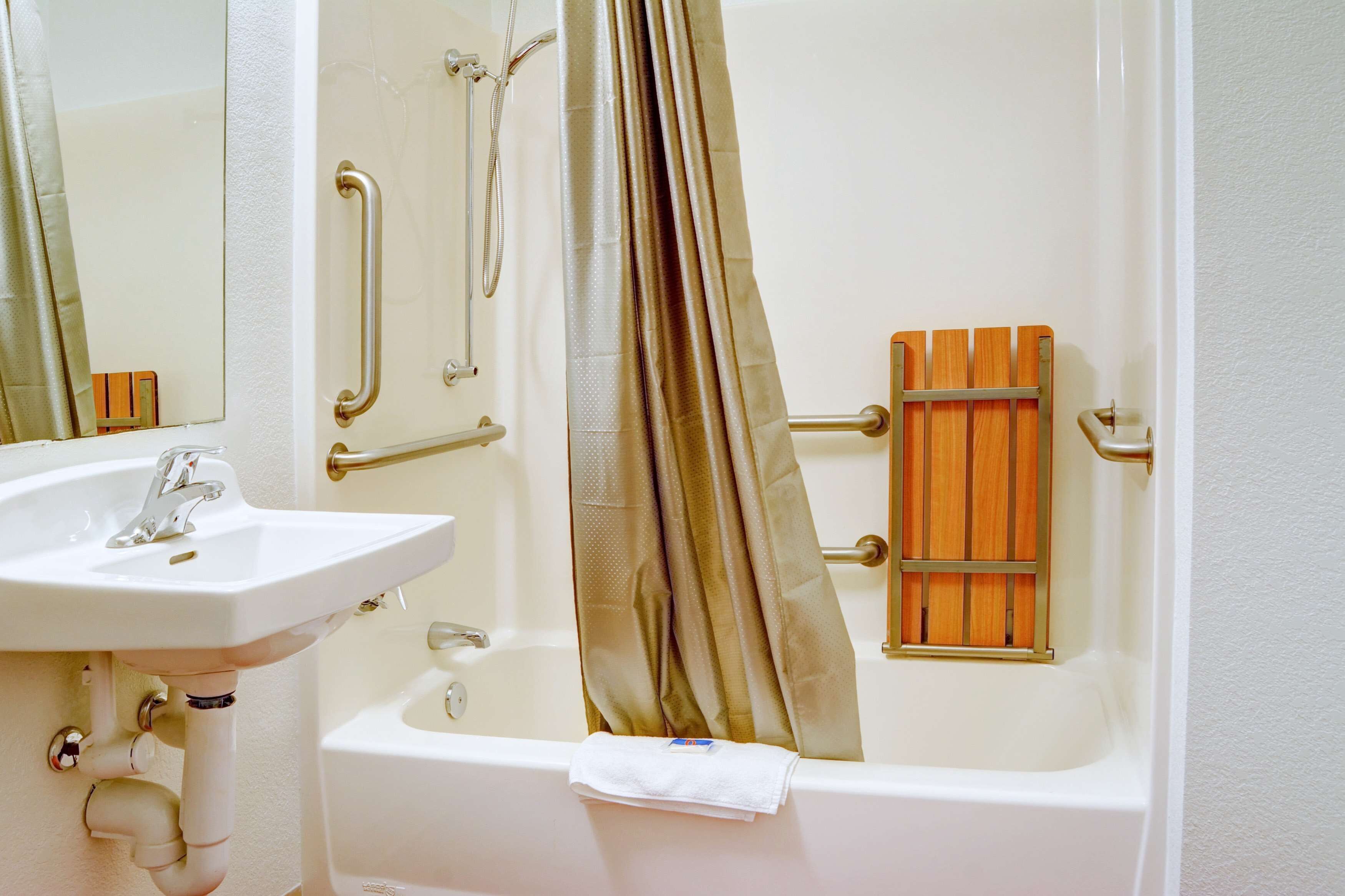 A bathroom with a white sink, a bathtub, and a shower curtain.