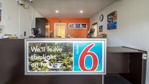 Un mostrador de recepción de motel con un letrero que dice 'Dejaremos la luz encendida para usted'.
