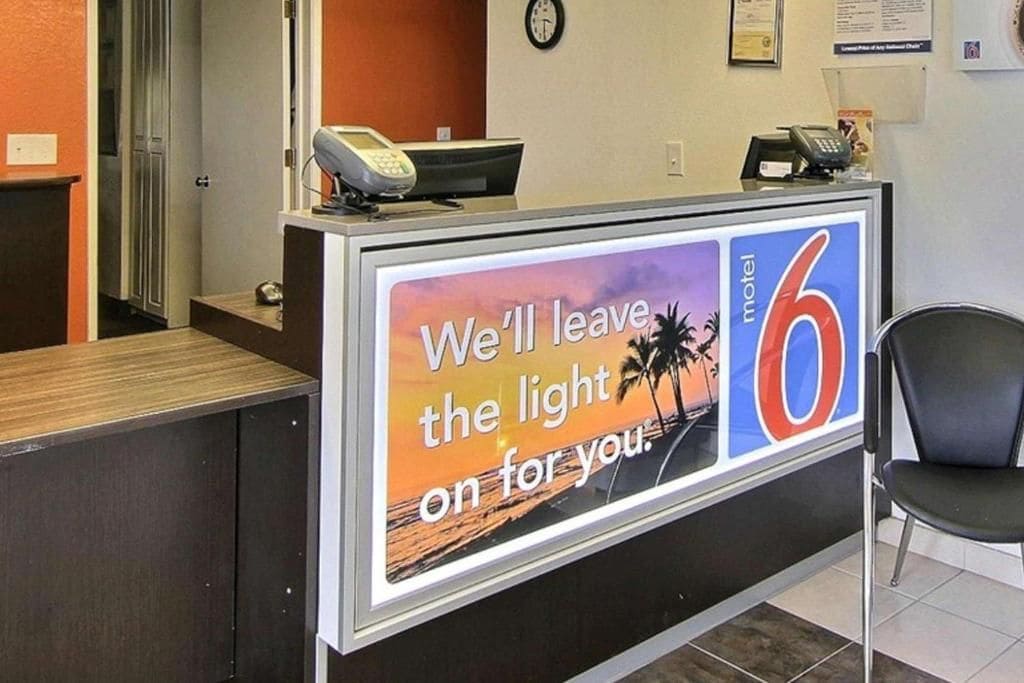 A reception desk with a sign that reads 'We'll leave the light on for you.'