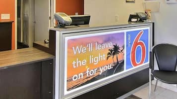 A reception desk with a sign that reads 'We'll leave the light on for you.'