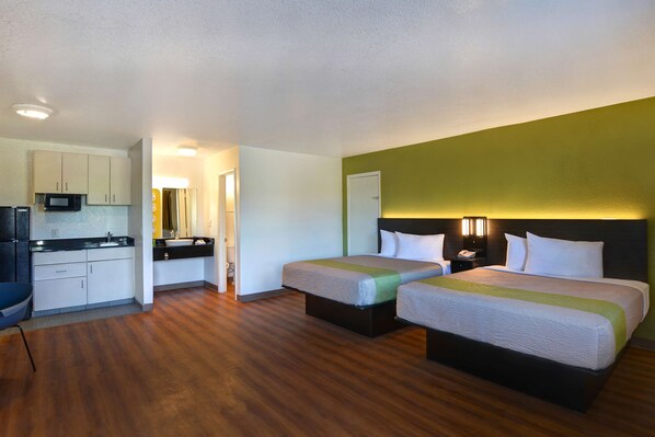 A hotel room with two beds, a kitchenette, and a bathroom. - Motel 6 Cocoa Beach, FL (Cocoa Beach)