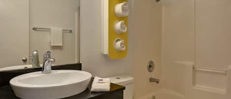A bathroom with a sink, mirror, towel rack, and a shower area.