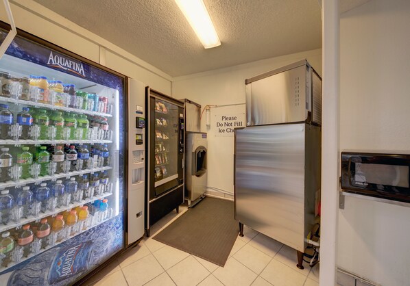 A vending machine stocked with various beverages and a refrigerator. - Motel 6 Cocoa Beach, FL (Cocoa Beach)