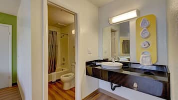 A bathroom with a sink, mirror, and towel rack.