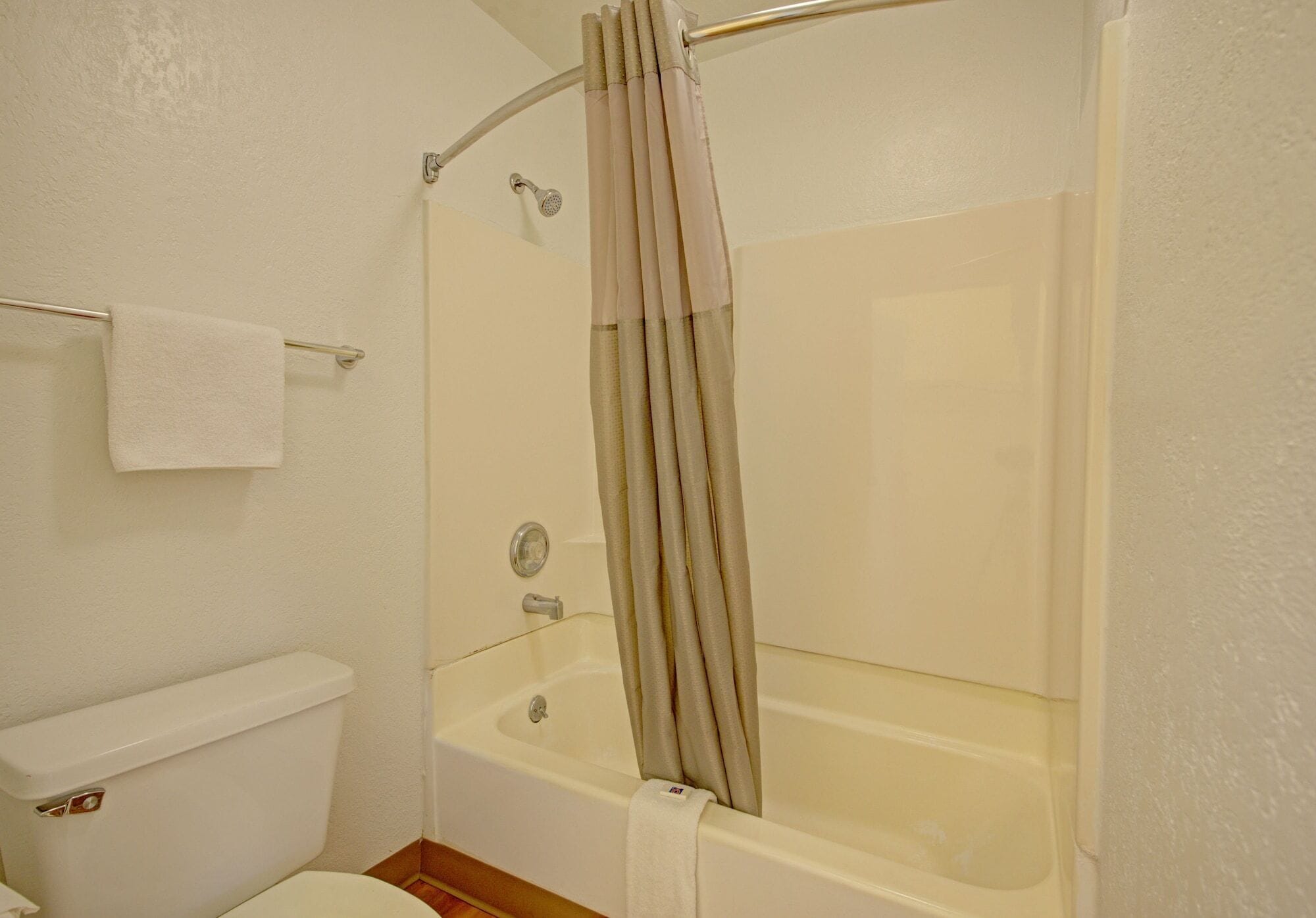 Une salle de bain avec une baignoire, des toilettes et un porte-serviettes.