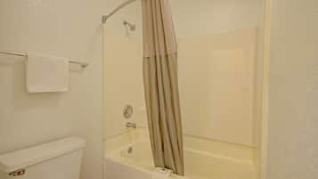 Une salle de bain avec une baignoire, des toilettes et un porte-serviettes.