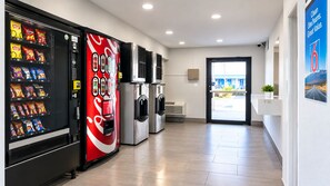 A clean, modern lobby with vending machines, air conditioning units, and a view of the outside. - Motel 6 Amarillo, TX - West (Amarillo)