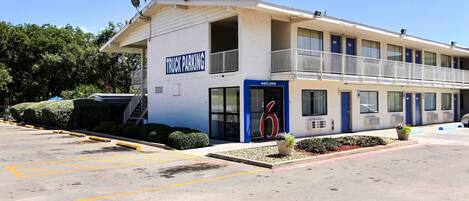 A building with a 'Truck Parking' sign, a 'Welcome' sign, and a number '6' sign.