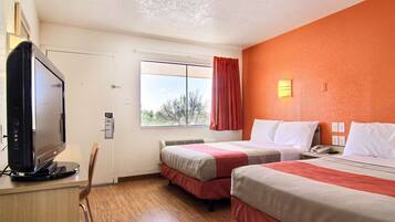 A hotel room with two beds, a television, a window with a view, and a red curtain.