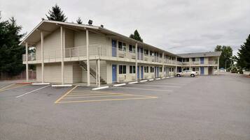 A motel with a two-story structure, a covered outdoor area, and a parking lot.
