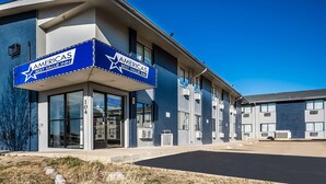 A modern building with a blue and white exterior, featuring large windows and a prominent sign for Americas Best Value Inn. - Americas Best Value Inn East Peoria (East Peoria)