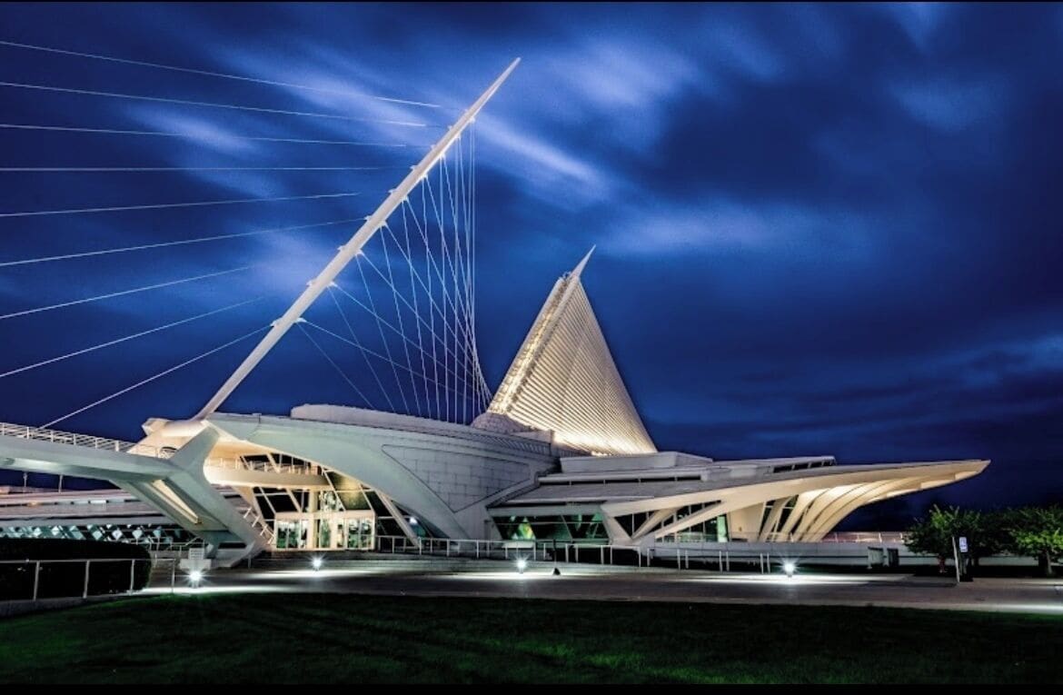 Un edificio de arquitectura moderna con una estructura distintiva en forma de vela y un techo triangular.