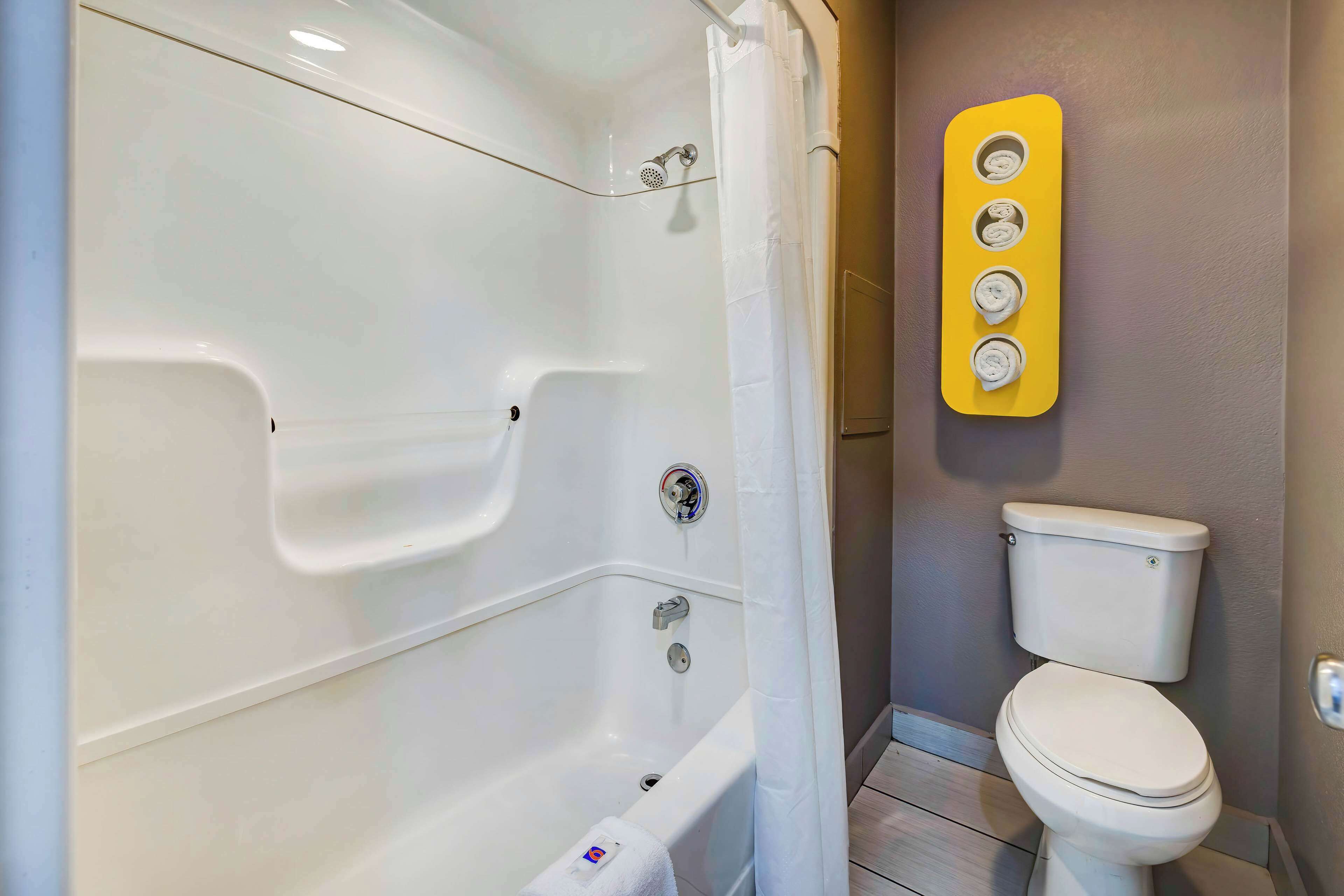Un baño con bañera, inodoro y un perchero para toallas.