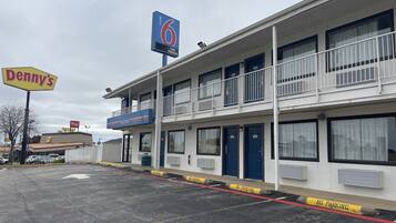A motel with a '6' sign, a 'Welcome' sign, and a 'No Parking' sign.