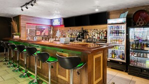 Een bar met een houten toonbank, groene barkrukken en een neonreclame.