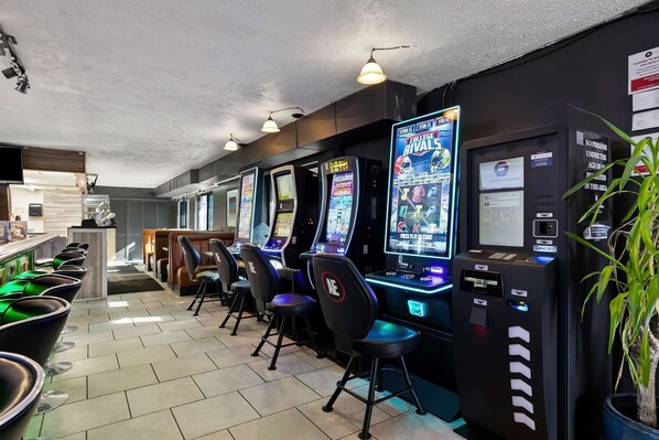 A row of gaming machines with chairs in a modern indoor setting. - Americas Best Value Inn Lincoln Airport (Lincoln)