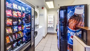 A vending machine with snacks and a microwave, a washing machine, and a Pepsi vending machine in a hotel room. - Motel 6 Wheat Ridge, CO - West - Denver North (Wheat Ridge)