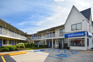 A motel with a 'welcome' sign, a parking lot with handicapped spaces, and a building with multiple balconies. - Motel 6 Southington, CT - Hartford (Southington)
