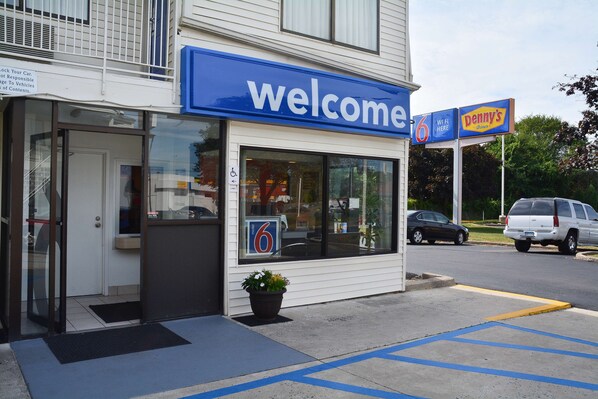 A building with a 'welcome' sign and a 'Penny's Diner' sign. - Motel 6 Southington, CT - Hartford (Southington)