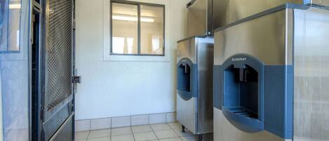 Una cocina comercial con electrodomésticos de acero inoxidable, una ventana y piso de baldosas.