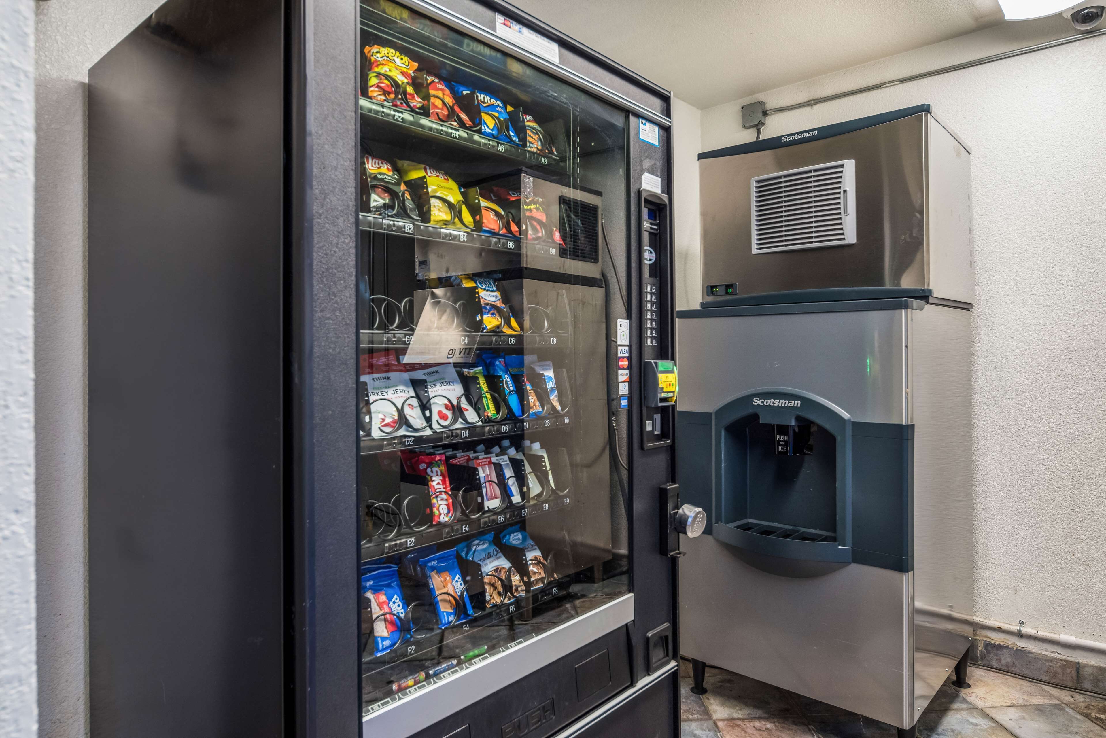A vending machine with various snack packages and a water dispenser.