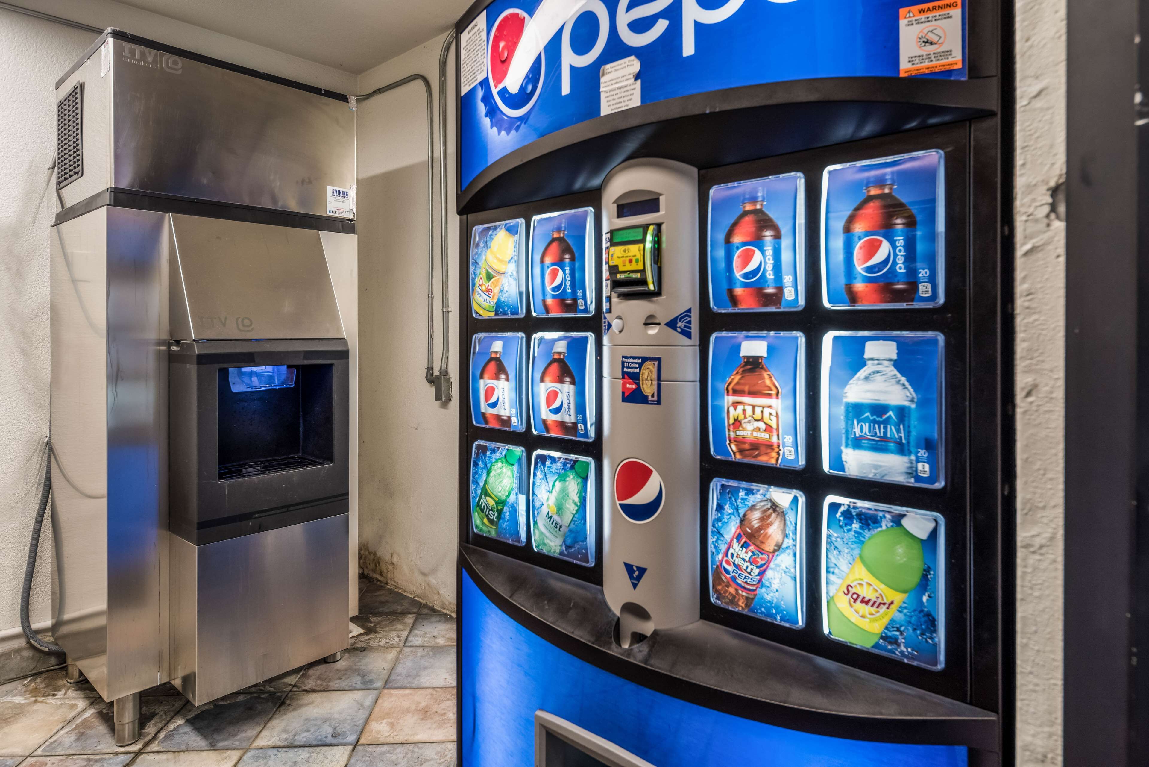 A vending machine with Pepsi and Aquafina water options, and a stainless steel appliance.