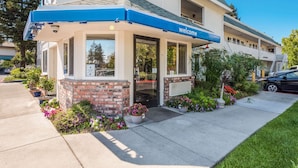 A hotel with a 'Welcome' sign, a brick facade, and a covered entrance. - Motel 6 Rohnert Park, CA (Rohnert Park)