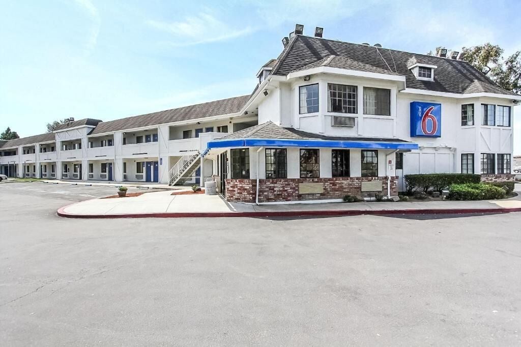 A motel with a covered front area and multiple guest rooms.