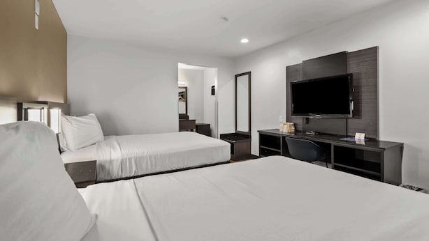 A hotel room with two beds, a desk, a TV, and a mirror. - Motel 6 Escondido, CA (Escondido)