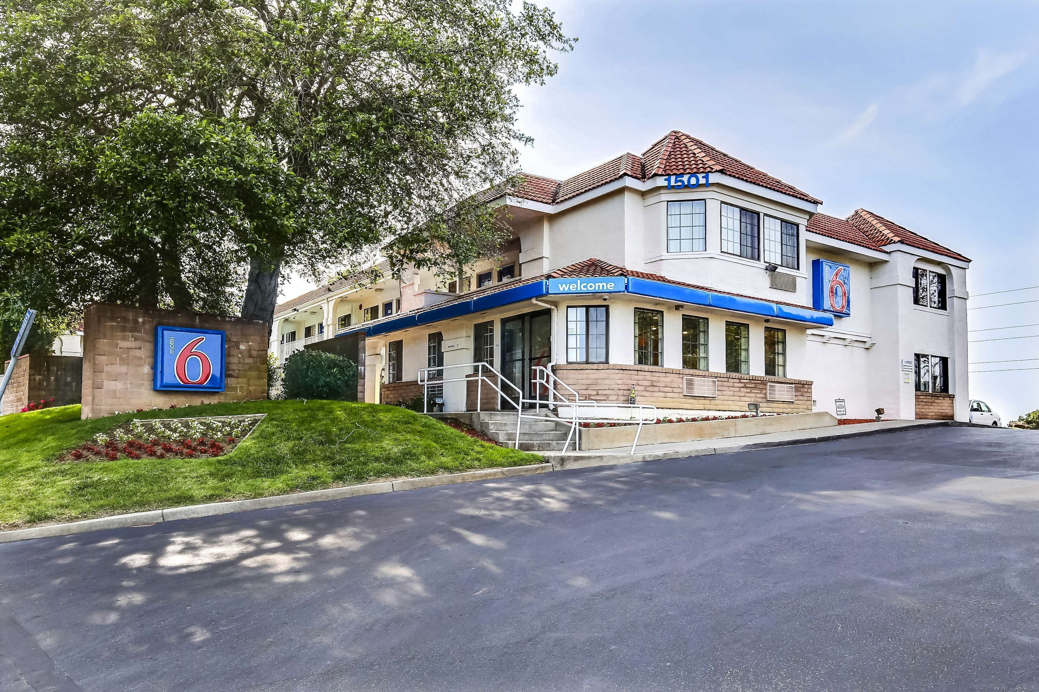 A hotel with a '6' sign, a 'welcome' sign, and a number '150' on the building.