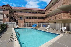 Relax by the pool surrounded by comfortable lounge chairs and a fun blue slide.