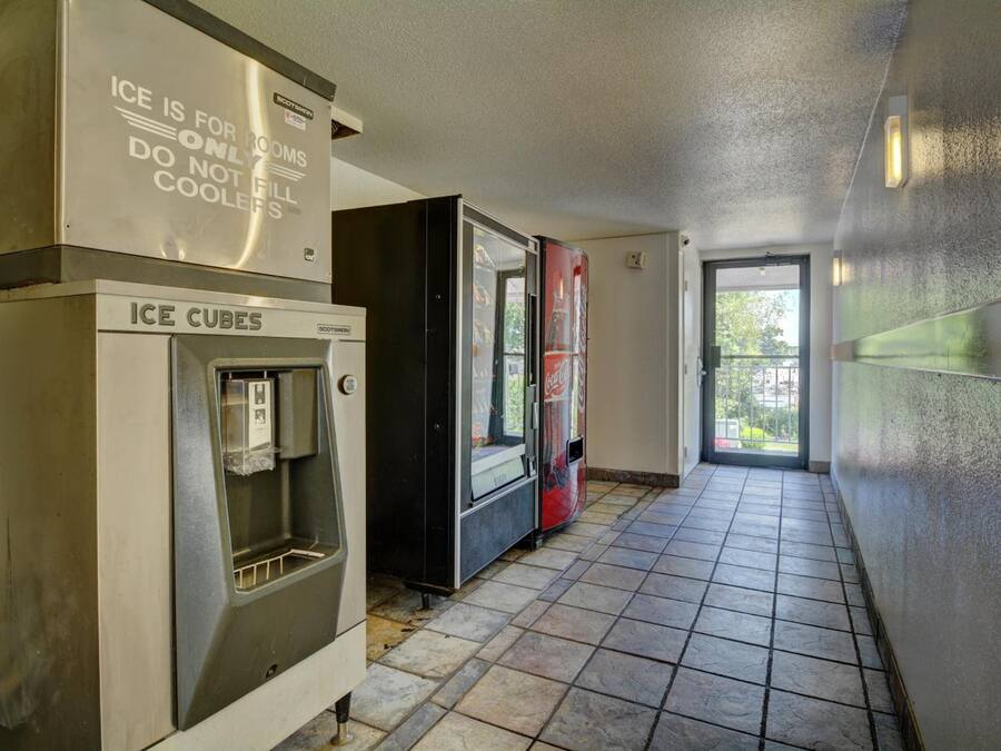 A corridor with ice cube dispensers and a Coca-Cola refrigerator.